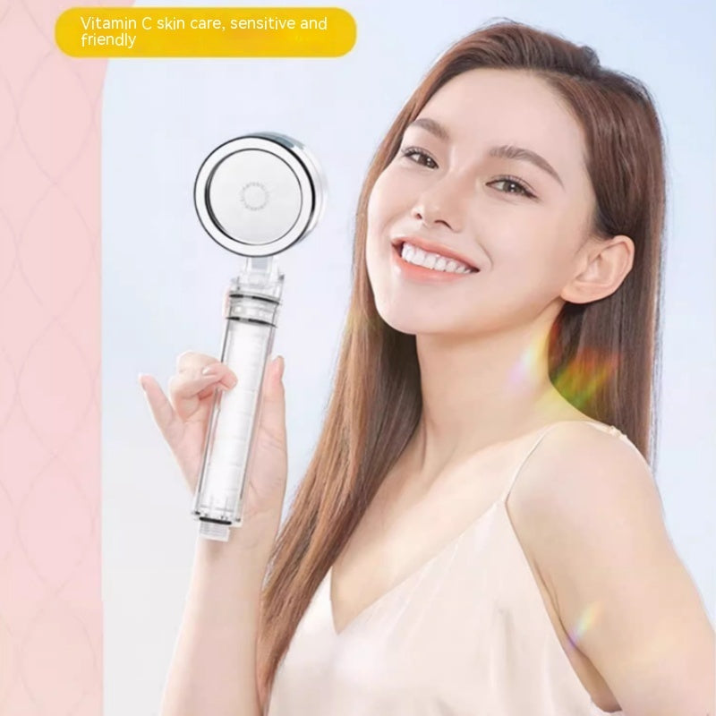 Chlorine removal skincare shower nozzle with vitamin C, held by a smiling person.
