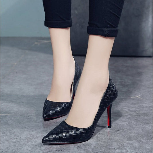 Black high heel shoes with striped pattern and pointed toe design.