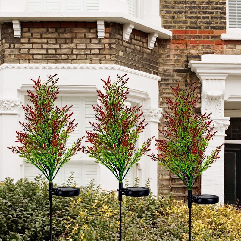 Solar-powered Christmas lights on pine and cypress trees, outdoor decorative lamps.
