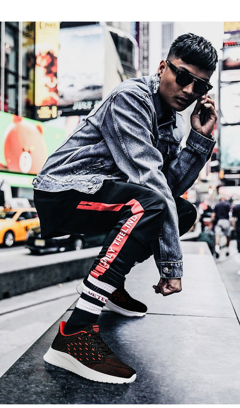 Man wearing Sports Flying Woven Cold Sticky Ultralight Casual Running Shoes in urban setting.