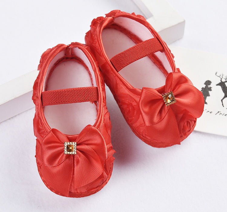 Newborn princess style red toddler shoes with silk upper and anti-slip sole.