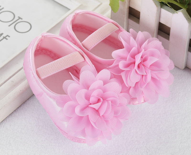 Newborn pink silk toddler shoes with floral design and anti-slip sole.