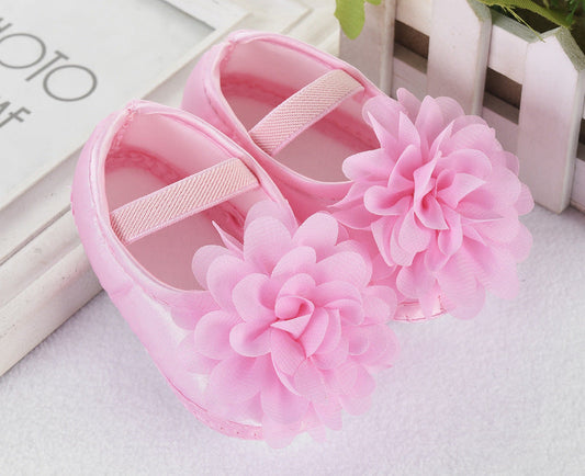 Newborn pink silk toddler shoes with floral design and anti-slip sole.