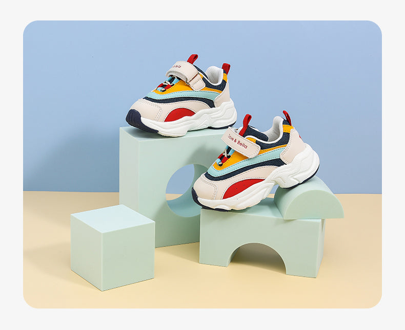 Children's western style sports shoes with colorful design and velcro straps, displayed on geometric shapes.