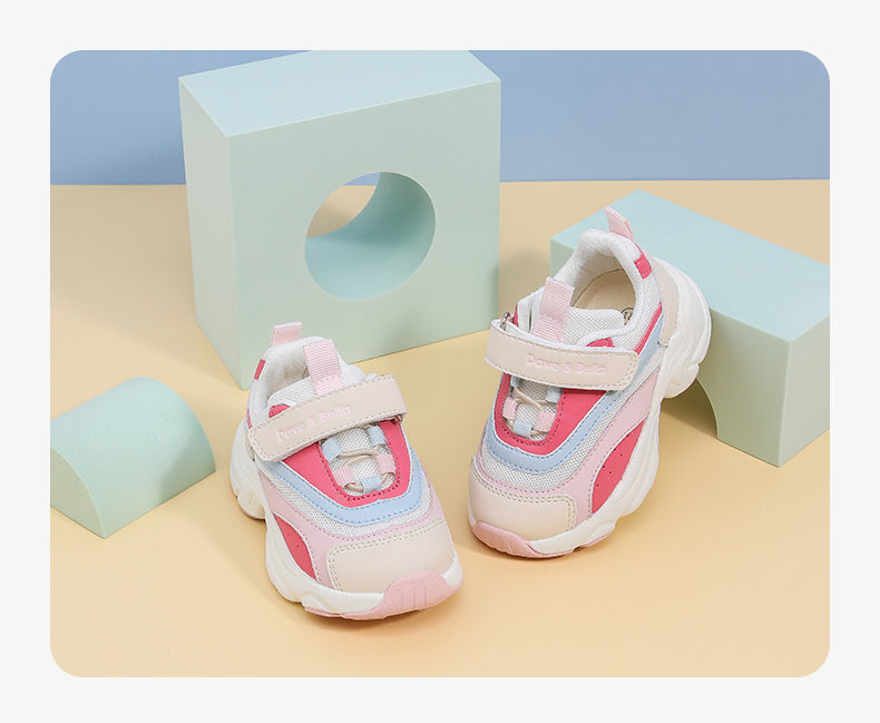 Colorful toddler sports shoes with Velcro, styled for boys and girls, displayed on pastel geometric shapes.