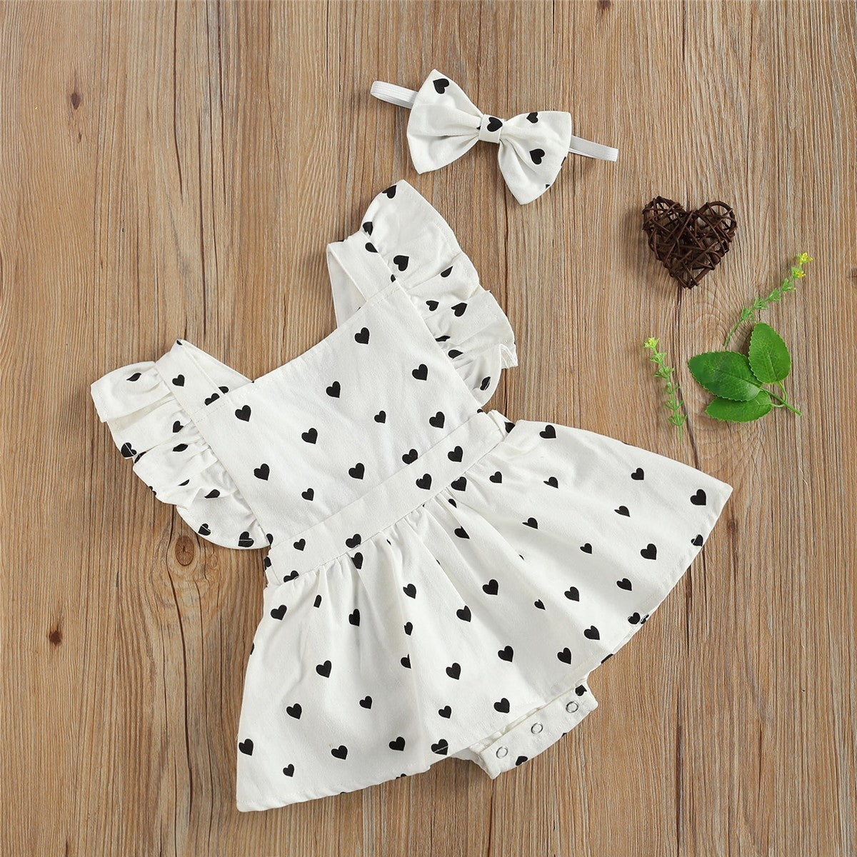 Girls' white dress with black heart pattern and matching bow headband for holidays.