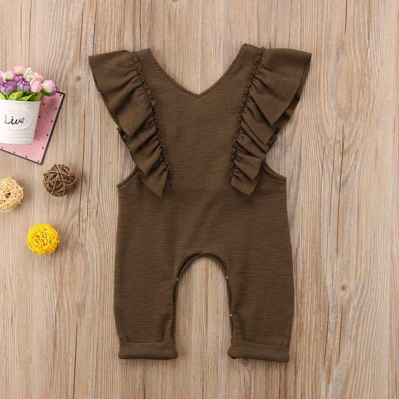 Baby girl brown knitted ruffle jumpsuit long sleeve romper on wooden background.