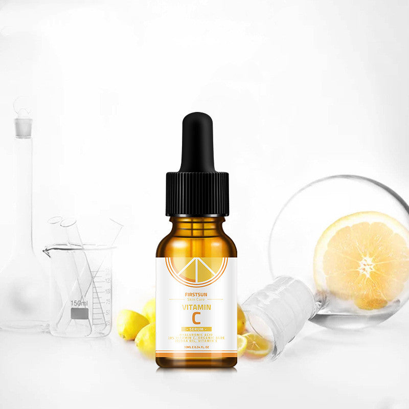 Vitamin C essence stock in amber bottle with dropper, surrounded by lemons and laboratory glassware.