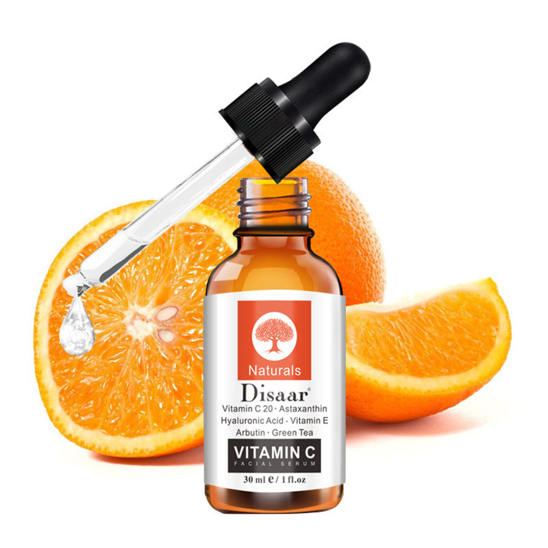 Vitamin C Serum bottle with dropper in front of fresh oranges, 30ml facial brightening serum.