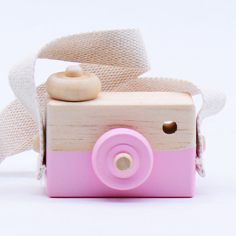 Cute wooden toy camera for kids aged 3+, pastel pink with adjustable strap.