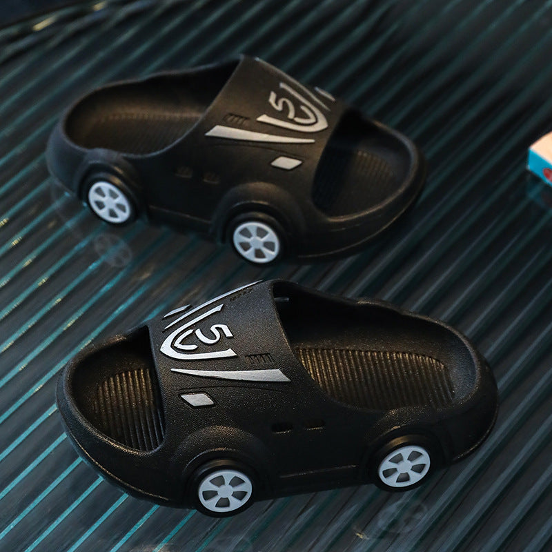 Cartoon-style black kid baby slippers with car design and PVC material.
