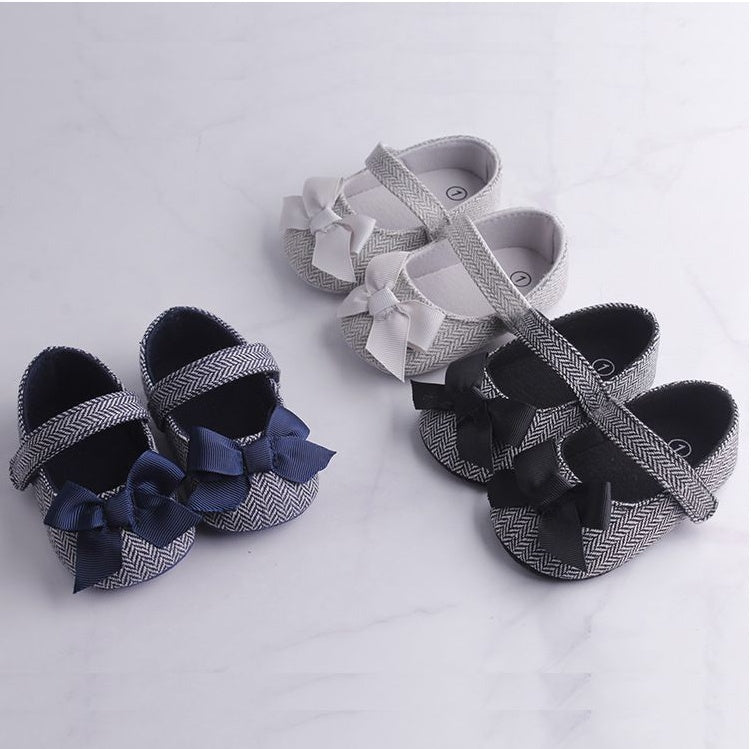 Toddler crib shoes with bows for baby boys in navy, grey, and black.