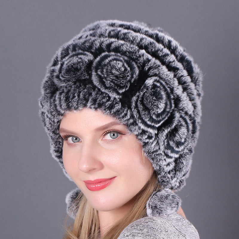 Womens Rabbit Fur Hat in dark grey with lighter textured rows, floral details and hanging pom-poms.