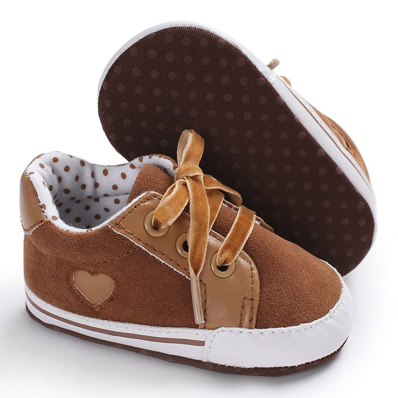 Brown baby sneakers for toddlers with non-slip soles and heart detail.