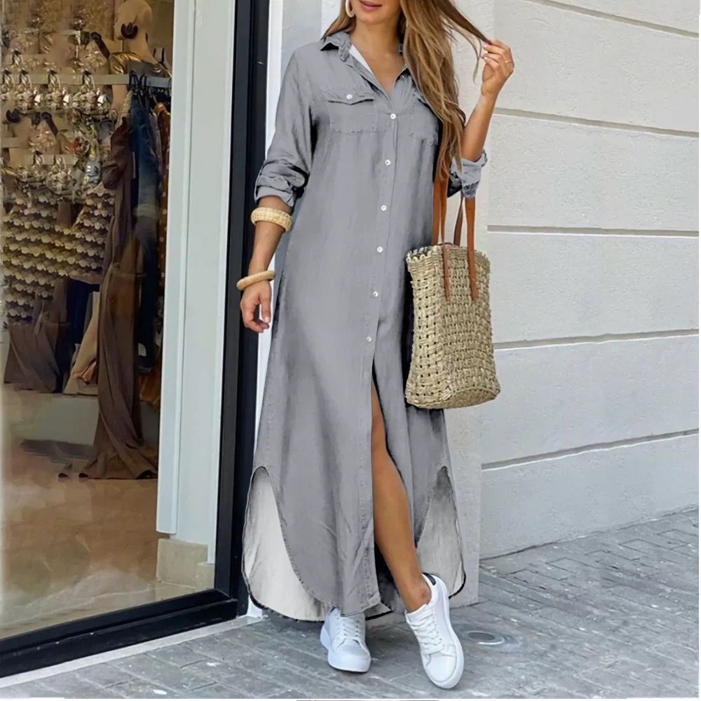 Casual long summer shirt dress for women, plus size, with rolled sleeves and slit, in grey, paired with white sneakers and a woven tote.