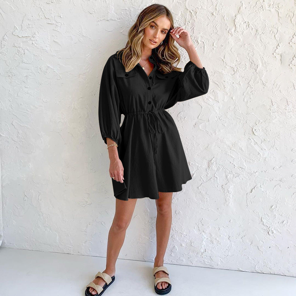 Women's casual black dress with long sleeves and button details.