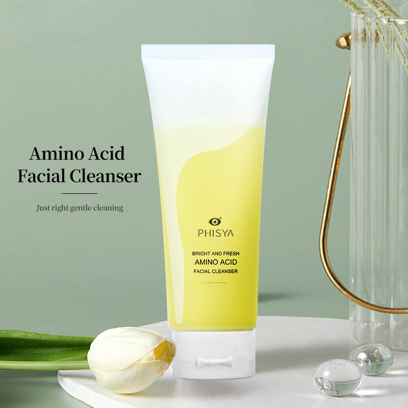 Amino acid facial cleanser in yellow and white tube against neutral background with flower and glass object.