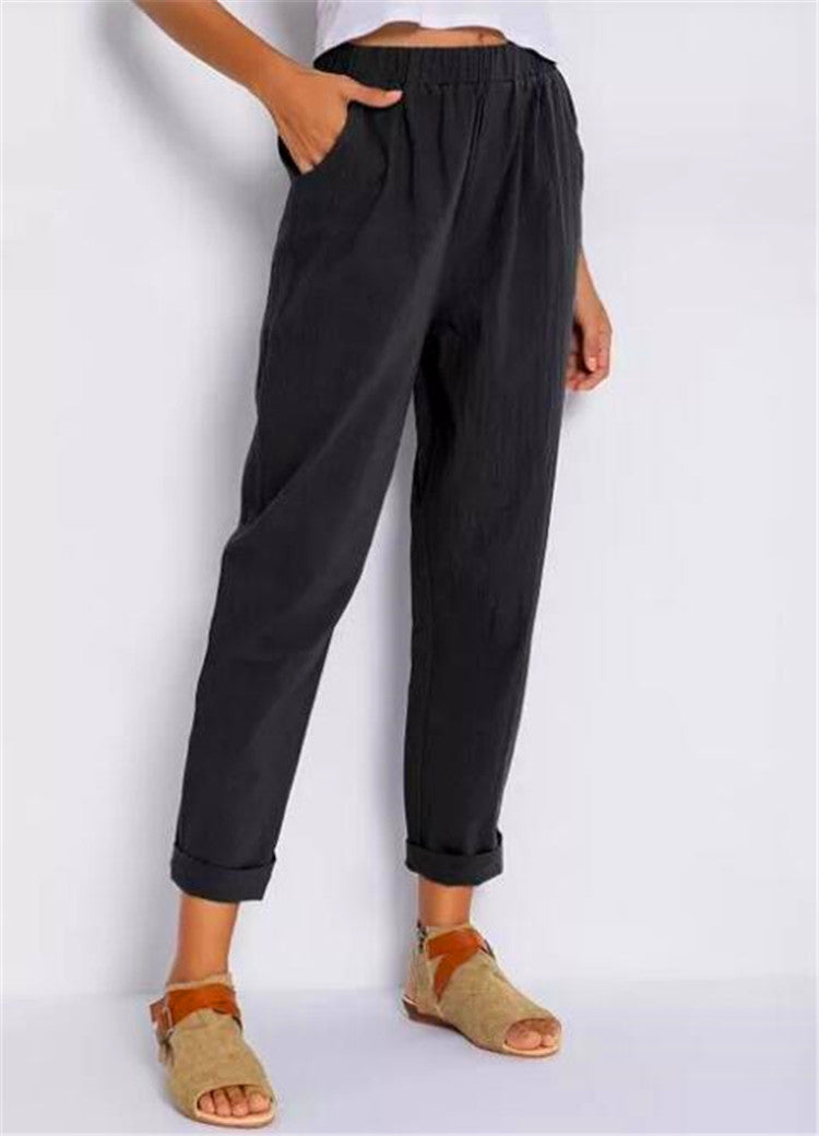 Casual Harem Pants in a dark shade, shown on a standing model with turned up hems and tan sandals