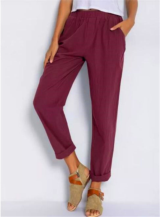 Casual Harem Pants in a dark shade, shown on a standing model with turned up hems and tan sandals