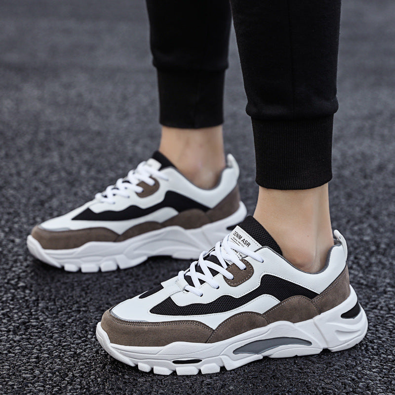 Mens Chunky Platform Sneakers in Brown with contrasting white and black panels, worn with black ankle-length trousers.