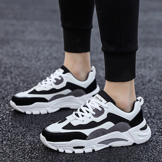 Mens Chunky Platform Sneakers in the White colourway with black and grey panels, worn with black joggers on grey pavement.