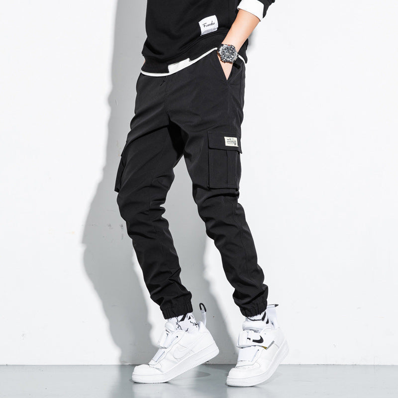Mens Cotton Cropped Trousers in Black on a model, showing the cargo pockets and gathered ankle finishes