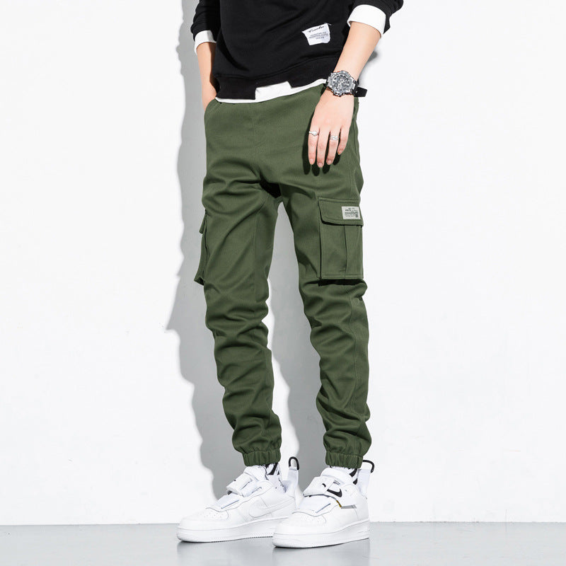 Mens Cotton Cropped Trousers in Green on a model, showing the plain fabric, cargo pockets and tapered silhouette