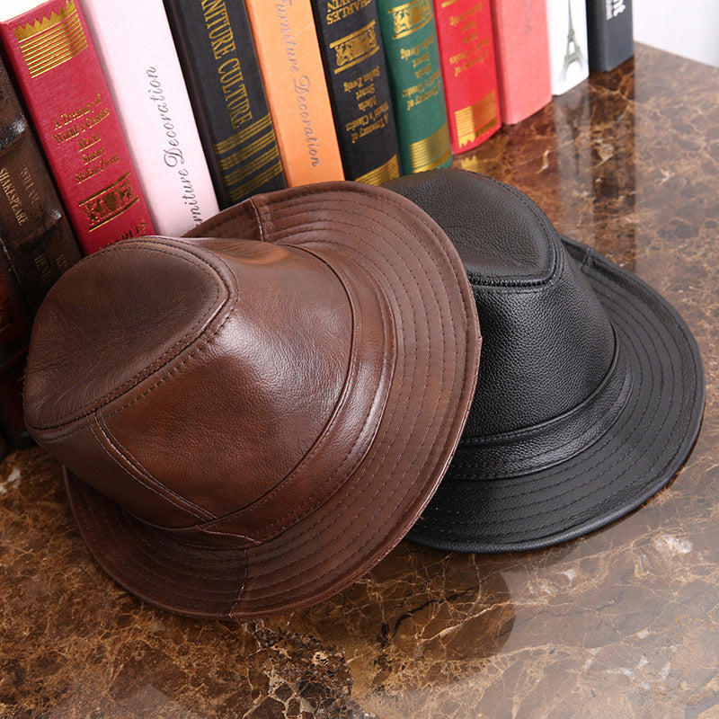 Mens Leather Fedora Hat in Black and Brown displayed together on a marble surface beside books