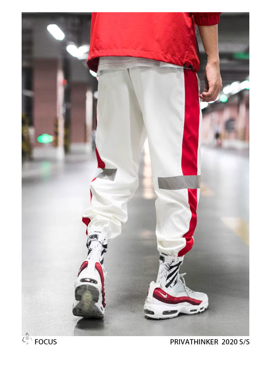 Mens Reflective Track Pants in White on a model, rear view showing red side panels and gathered ankle finishes