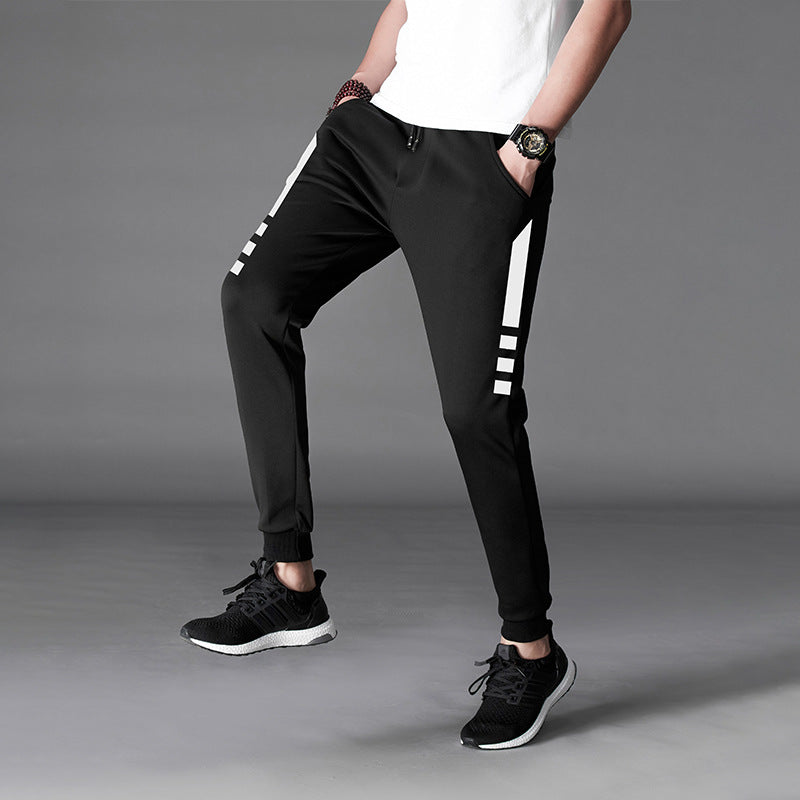 Mens Slim Fit Harem Pants in Black on a model, angled view showing white printed detailing along the outer leg