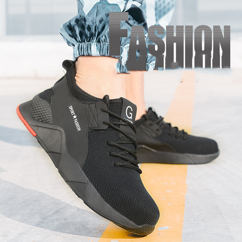 Mens Steel Toe Work Shoes Style 3 in black with broad side panels and a red heel accent, worn with blue trousers.