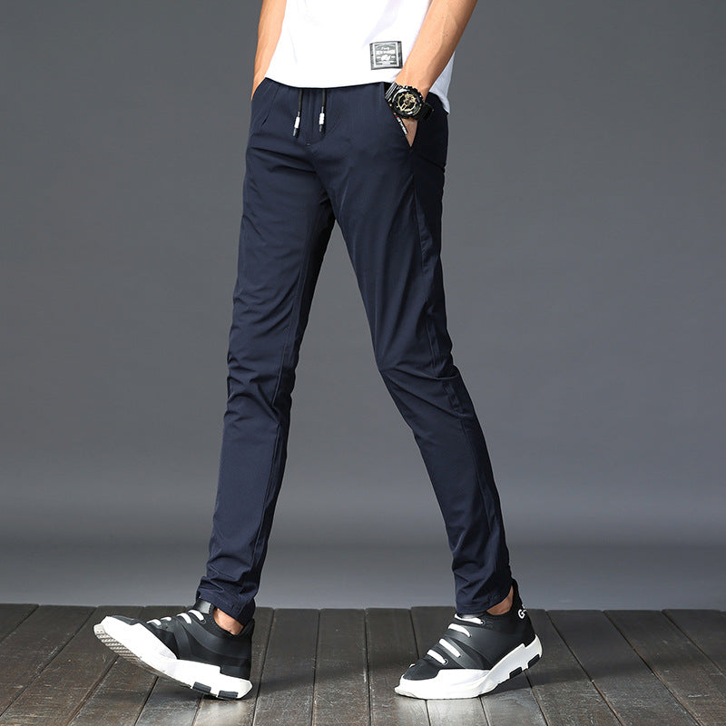 Mens Thick Stretch Trousers in Blue on a model, angled view showing the slim legs and black trainers