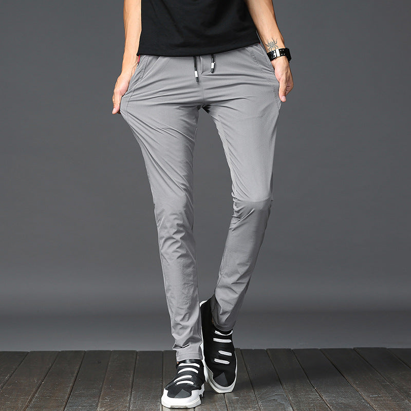 Mens Thick Stretch Trousers in Gray on a model against a grey background, showing the drawstring waist and slim legs