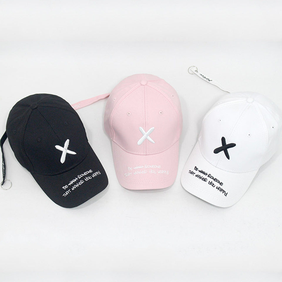 Unisex Embroidered Baseball Cap displayed in black, pink and white with contrasting X embroidery and lettering on the curved peaks.