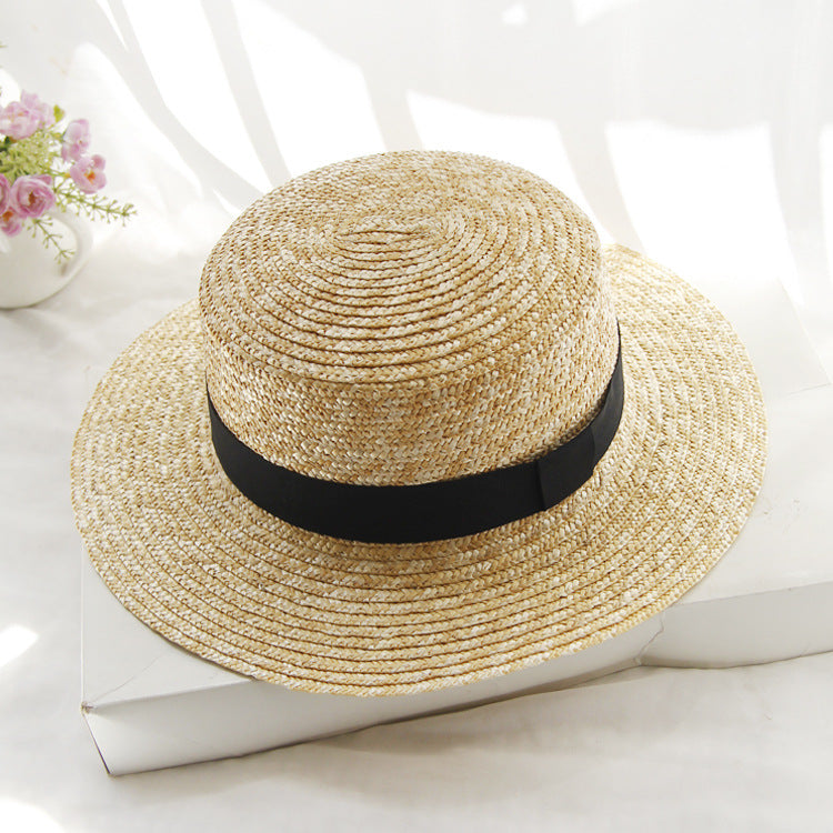 Womens Boater Straw Hat in natural straw tones with a flat crown, wide brim and plain black ribbon band.