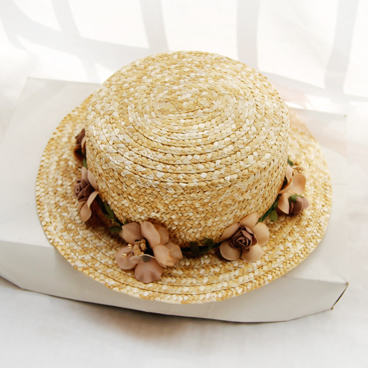 Womens Boater Straw Hat in natural straw tones with a floral garland around the crown and a short brim.