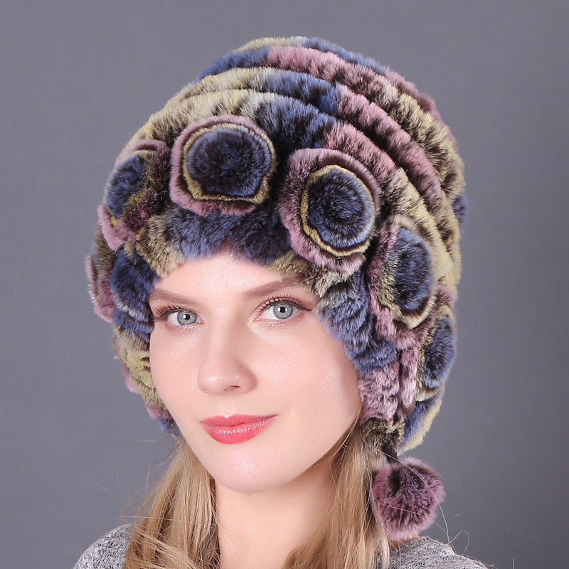 Womens Rabbit Fur Hat in muted green, pink and blue tones with floral details and hanging pom-poms.
