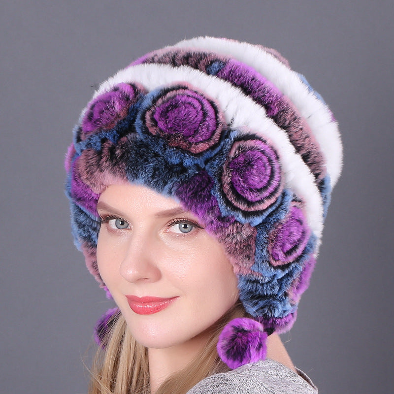 Womens Rabbit Fur Hat in purple, blue and white with floral details and purple hanging pom-poms.