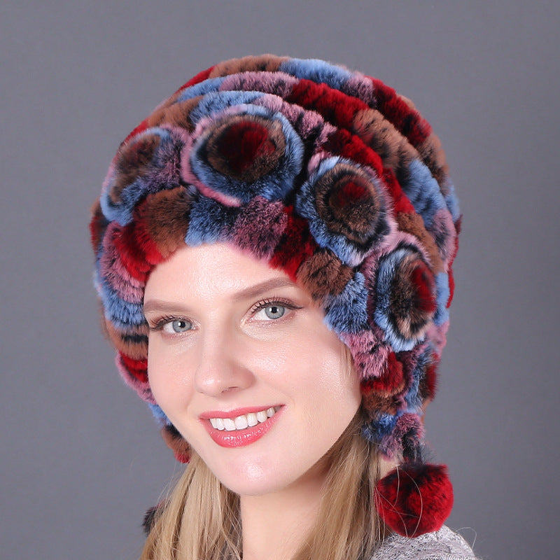 Womens Rabbit Fur Hat in red and blue tones with multicolour floral details and red hanging pom-poms.