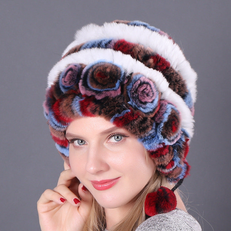 Womens Rabbit Fur Hat in white, red and blue tones with multicolour floral details and red hanging pom-poms.