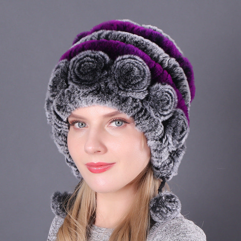 Womens Rabbit Fur Hat with purple and grey stripes, grey floral details and hanging pom-poms, shown from the front.