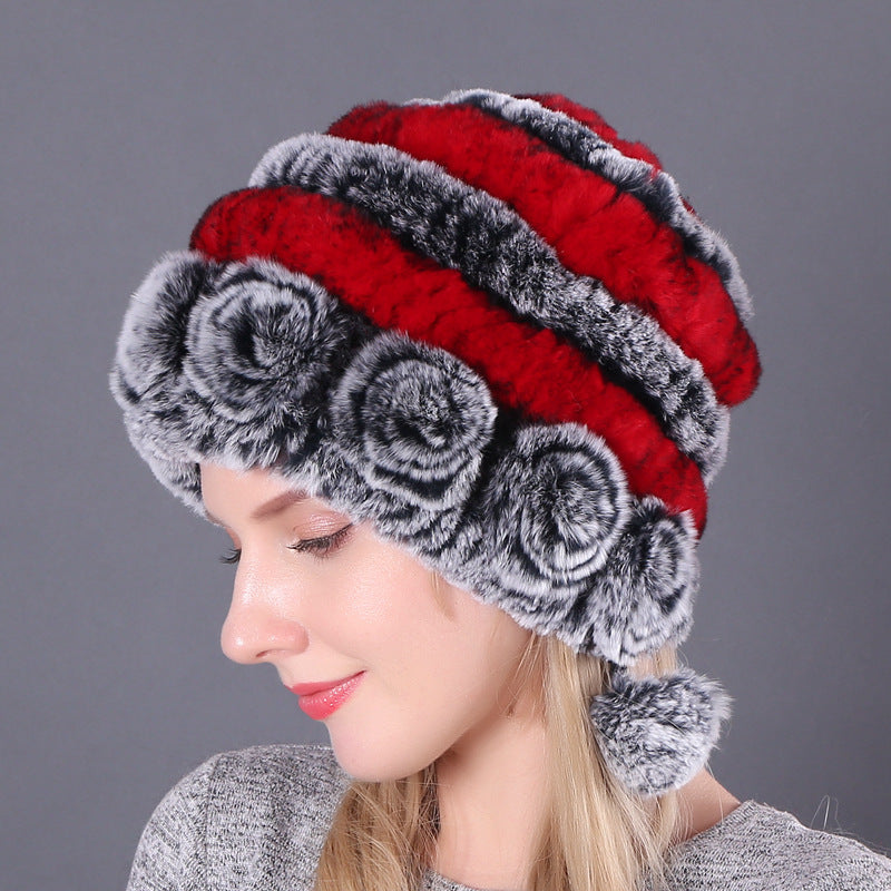 Womens Rabbit Fur Hat with red and grey stripes, grey floral details and hanging pom-poms, shown from the side.