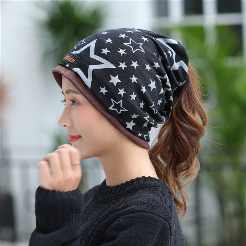 Womens Star Print Beanie in black with white and grey stars, worn in a slouchy style by a model.