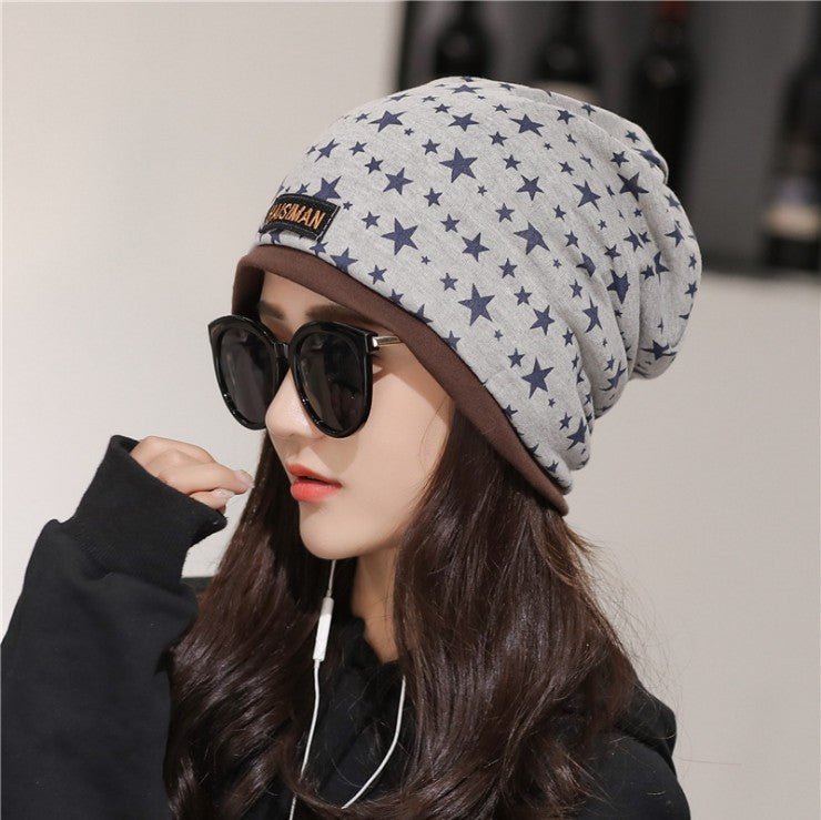 Womens Star Print Beanie in khaki with dark stars, worn by a model with sunglasses.