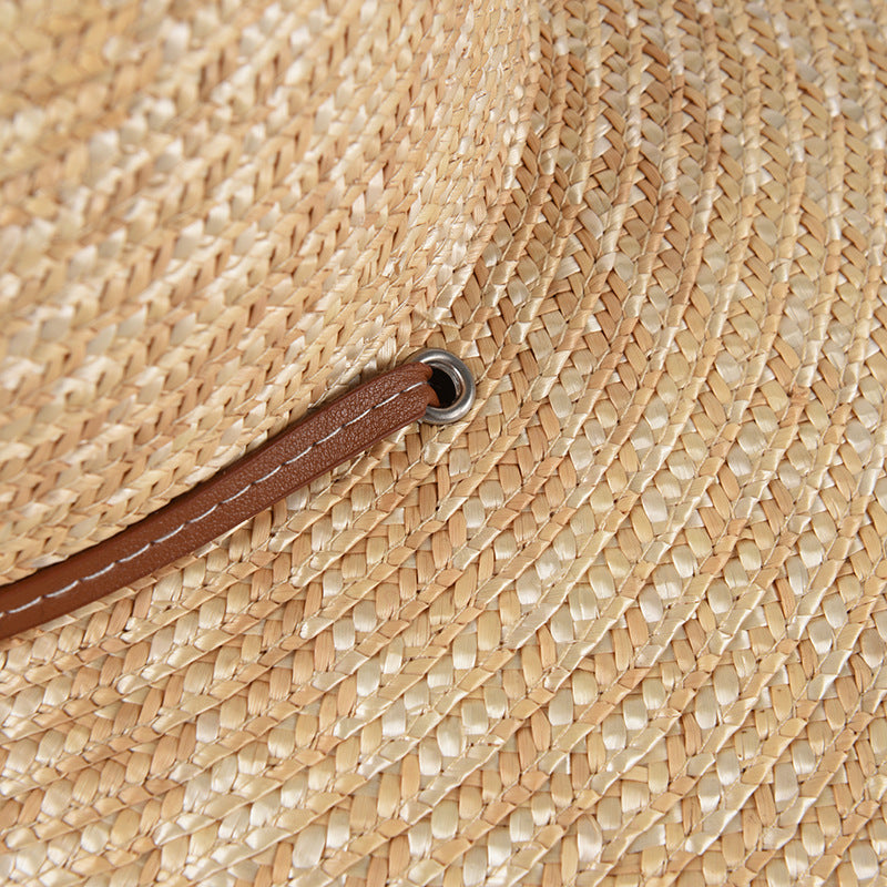 Womens Wide Brim Straw Hat close-up showing the woven straw texture and brown strap passing through an eyelet.