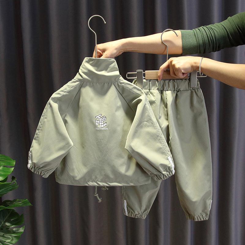 Boys Sports Two-Piece Suit in green displayed on hangers with matching sports trousers