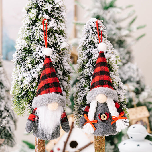 Christmas decoration faceless dolls with red and black plaid hats and beards, set against snowy trees.